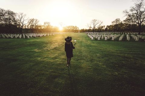 sad woman cemetery holding bouquet roses