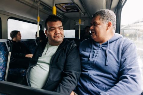 2 men sitting together on a bus